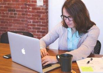 A woman using Nexyta software for work at a table.