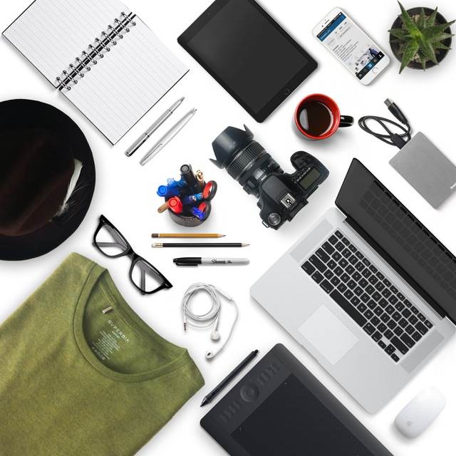 A photo of a laptop, camera, phone and other items on a white background.