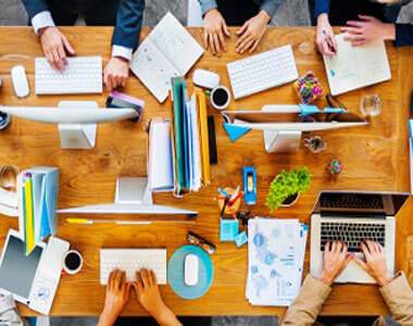 A group of people working at a desk.